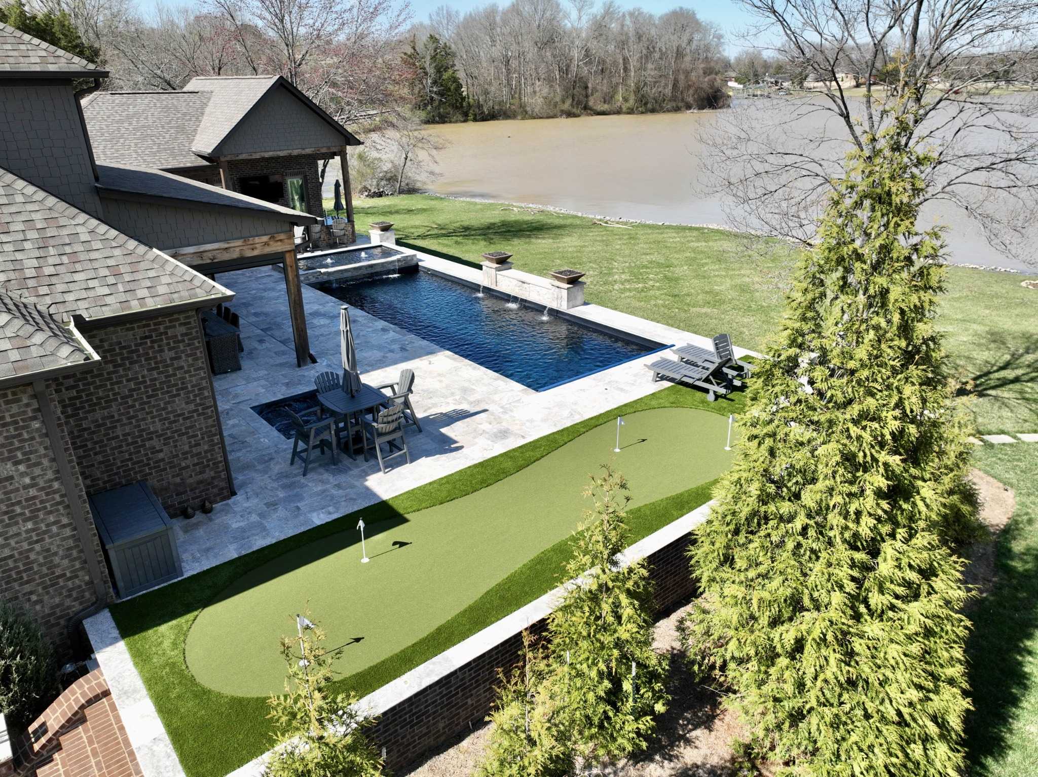 Aerial shot of a custom pool and putting green by a lake in Nashville by Bedrock Pools Nashville
